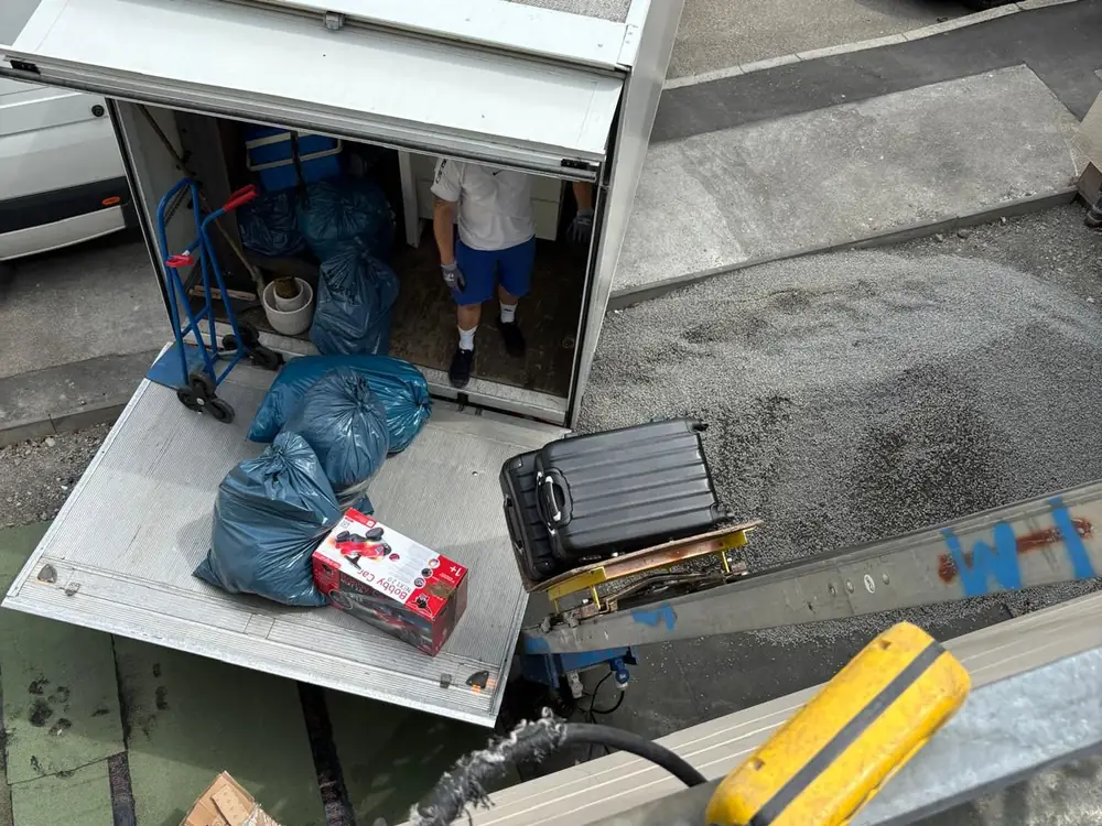 Entrümpelung in Waiblingen: beladene Ladebordwand des Transporters, im Vordergrund die Schiene des Außenaufzugs